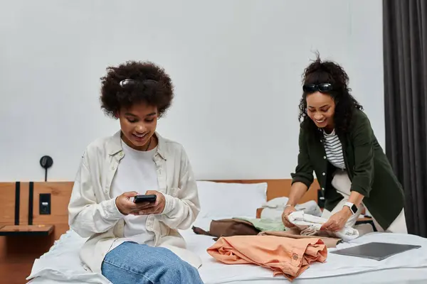 A happy couple relaxes in their hotel room, sharing laughter and organizing their travel essentials. — Stock Photo