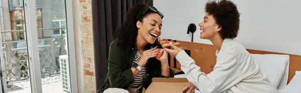 A happy couple enjoys each other's company, sharing laughter and treats in their cozy hotel room. — Stock Photo