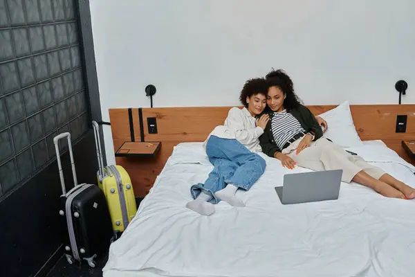 Ein glückliches Paar entspannt auf einem gemütlichen Bett und umarmt sich, während es einen ruhigen Moment in seinem Hotelzimmer genießt. — Stockfoto