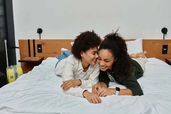 A happy couple enjoys laughter and closeness while relaxing on their hotel bed, creating cherished memories. — Stock Photo