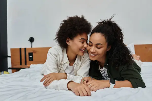 Um casal feliz compartilha risos e carinho enquanto relaxa em seu elegante quarto de hotel. — Fotografia de Stock