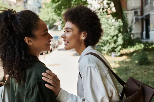 A happy lesbian couple shares laughter while exploring the outdoors on a sunny day. — Stock Photo