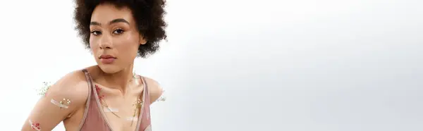 Chic curly haired woman posing with flowers on body and underwear. — Stock Photo