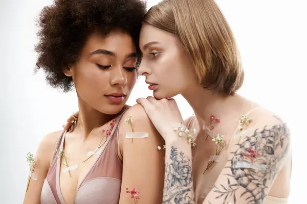 Dos mujeres comparten un momento íntimo adornado con acentos florales. - foto de stock