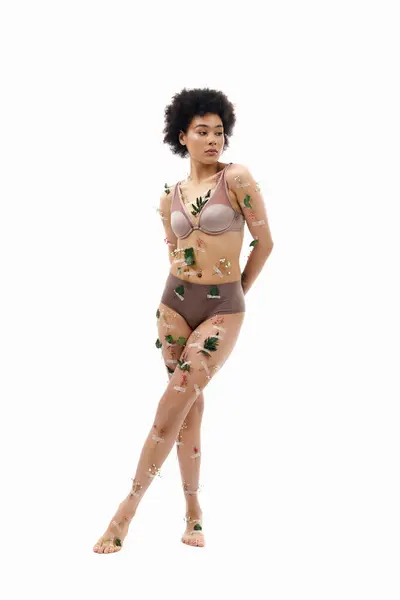 Lovely curly haired african american woman in pastel cozy underwear with flowers on body. — Stock Photo