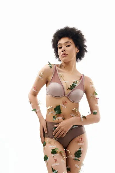Chic curly haired african american woman in pastel cozy underwear with flowers on body. — Stock Photo