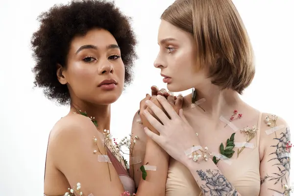 Two women share a tender moment adorned with flowers and gentle expressions. — Stock Photo