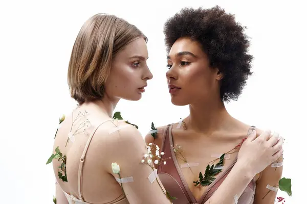 Two women share an intimate moment adorned with natural elements, reflecting love and unity. — Stock Photo