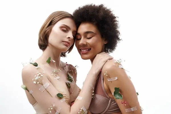 Two women embrace lovingly, surrounded by delicate floral accents. — Stock Photo