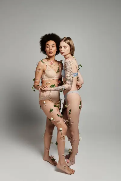 Two women embrace tenderly, adorned with delicate floral touches. — Stock Photo