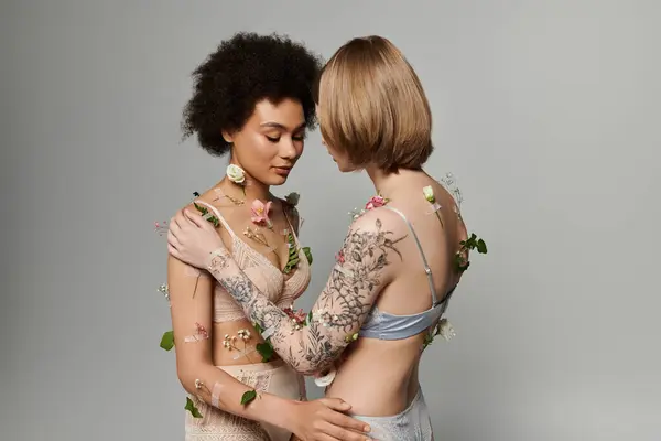 Two women share a tender moment surrounded by delicate flowers and soft light. — Stock Photo