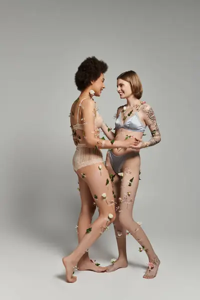Two women share a joyful moment, surrounded by delicate floral touches. — Stock Photo