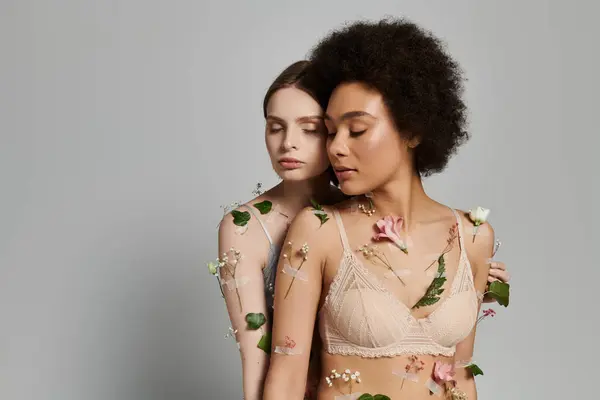 Two women share an intimate moment surrounded by soft flowers and greenery. — Stock Photo