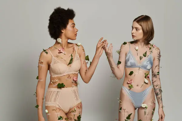Two women share a tender connection surrounded by delicate flowers. — Stock Photo