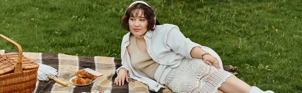 A young woman in a white shirt rests comfortably during a summer picnic, surrounded by nature. — Stock Photo