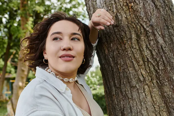 Eine junge Frau entspannt sich in einem lebendigen Park, sonnt sich in der Sommersonne und verbindet sich mit der Natur. — Stockfoto