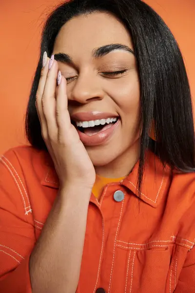 An expressive moment of laughter and joy captured with a warm backdrop. — Stock Photo