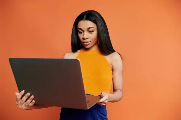 A confident woman explores new ideas on her laptop, immersed in creativity. — Stock Photo