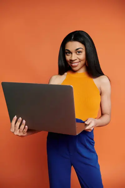 A woman smiles while holding her laptop, radiating confidence and creativity. — Stock Photo