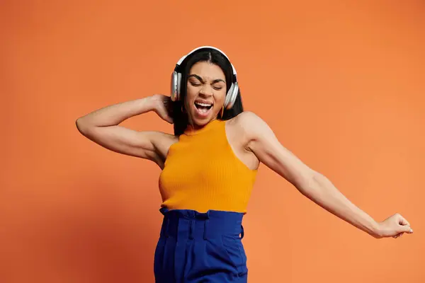 Uma mulher animada expressa alegria ao dançar com fones de ouvido em. — Fotografia de Stock