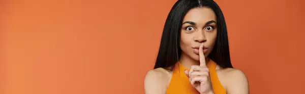A woman playfully asks for silence with a finger on her lips. — Stock Photo