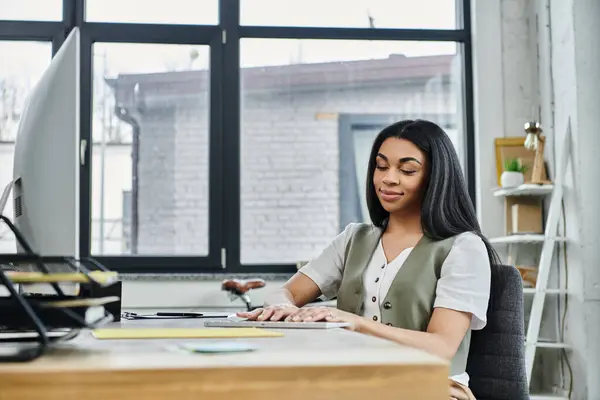 Woman concentrating while typing on a laptop in a stylish workspace. — Stock Photo