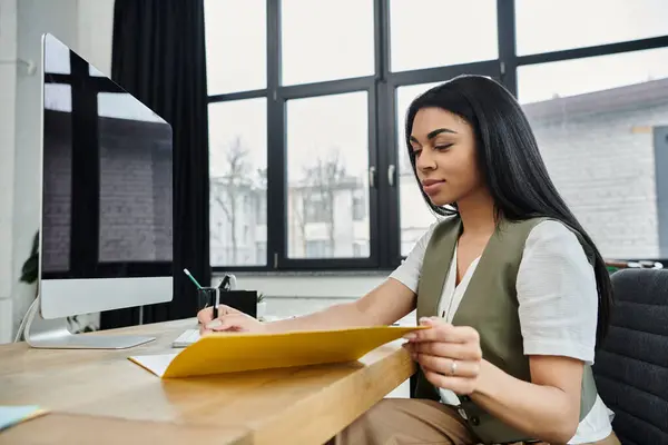 A focused woman writes notes in a stylish workspace filled with natural light. — Stock Photo
