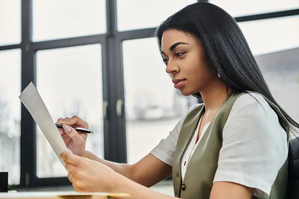 A woman carefully examines important papers with concentration. — Stock Photo