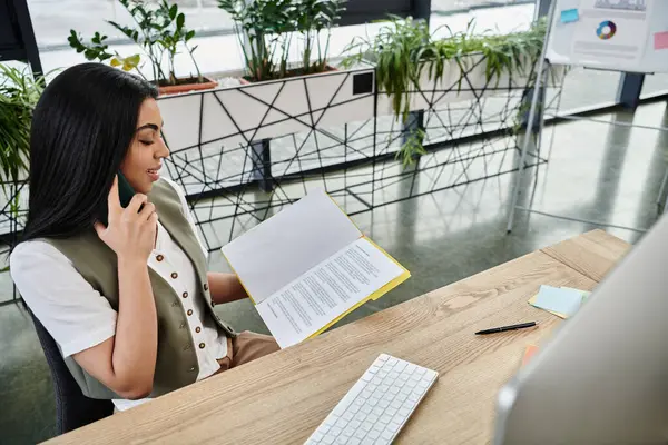 Woman confidently speaks on the phone while reviewing important documents. — Stock Photo