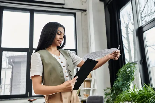 A confident woman examines important documents with focus and determination. — Stock Photo