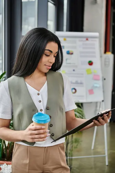 Woman engages thoughtfully while holding a coffee cup and reviewing notes. — Stock Photo