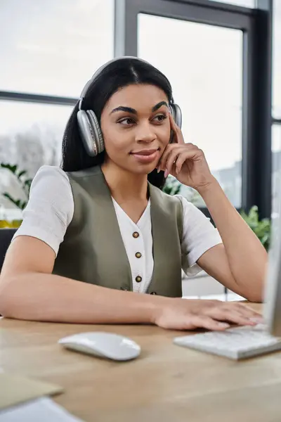 Jovem mulher escuta atentamente enquanto está envolvida no trabalho em sua mesa. — Fotografia de Stock