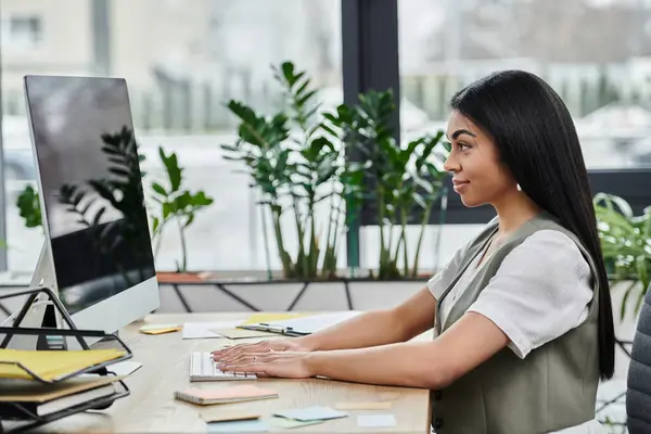 A young woman engages with her computer, immersed in her work. — Stock Photo