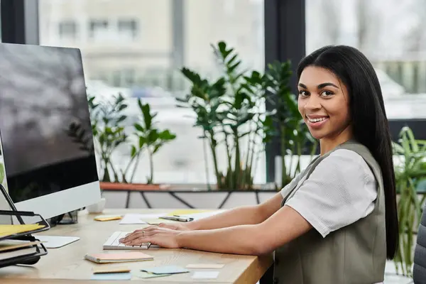 A young woman with a warm smile engaged in her work amid vibrant plants. — Stock Photo