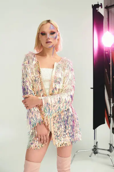 A young woman poses confidently in holographic attire with creative lighting. — Stock Photo