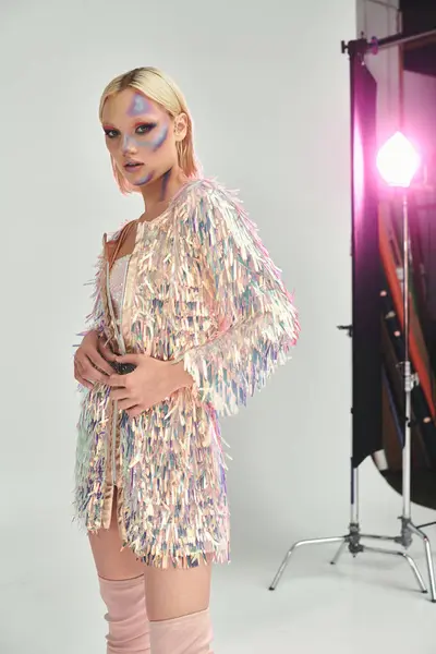 A stylish woman poses confidently, showcasing her holographic outfit and striking makeup. — Stock Photo