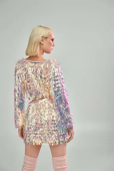 A stylish young woman showcases her shimmering outfit with confidence. — Stock Photo