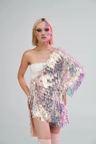Una joven mujer exuda elegancia en su atuendo holográfico, encarnando la moda moderna. - foto de stock