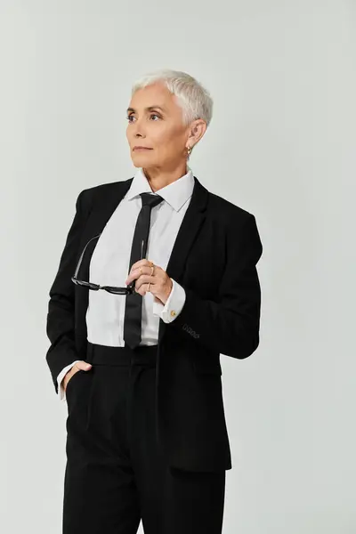 Mulher elegante mostra trajes elegantes com cabelo curto e uma expressão equilibrada. — Fotografia de Stock