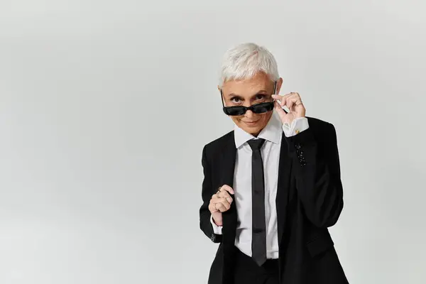 A confident woman showcases her fashion sense in a sleek outfit. — Stock Photo
