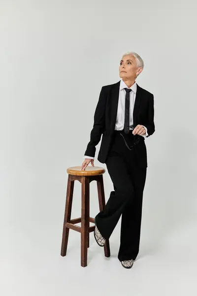A confident woman in stylish attire strikes a contemplative pose. — Stock Photo