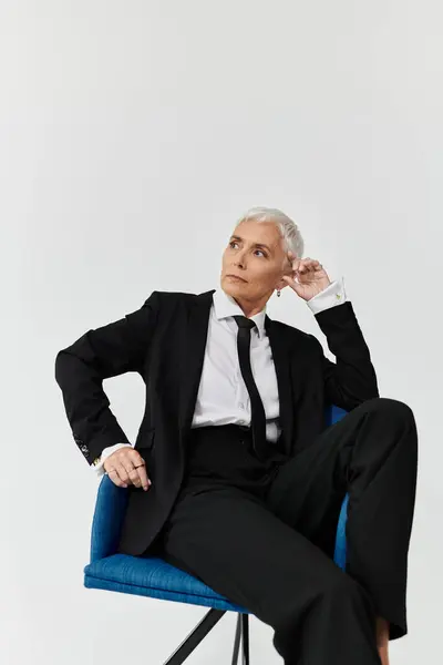 A sophisticated woman exudes confidence while seated in a chair. — Stock Photo