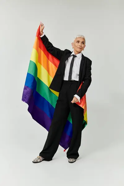 Confident woman with short hair proudly holding a rainbow flag. — Stock Photo