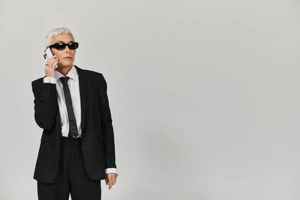 Confident individual dressed sharply, engaged in a phone conversation. — Stock Photo