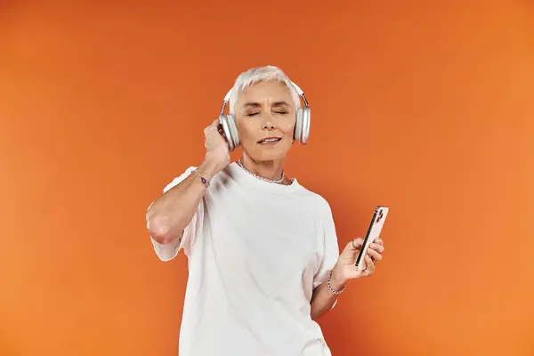 Eine fröhliche Frau taucht in Musik ein und schunkelt vor Freude. — Stockfoto