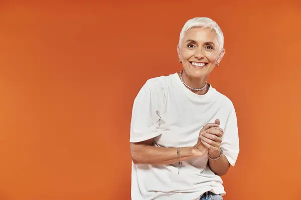Confident woman in trendy outfit smiles joyfully, exuding charm and warmth. — Stock Photo