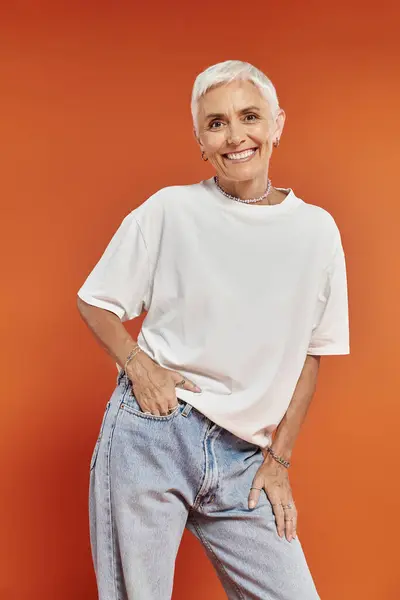 A confident woman smiles warmly while posing in trendy attire. — Stock Photo