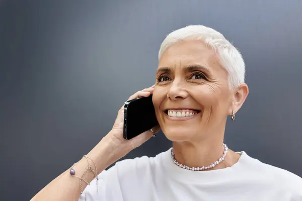 A vibrant woman smiles while talking on the phone, showcasing her chic style. — Stock Photo