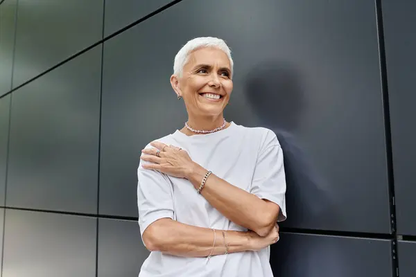 An elegantly dressed mature woman exudes confidence against a sleek backdrop. — Stock Photo