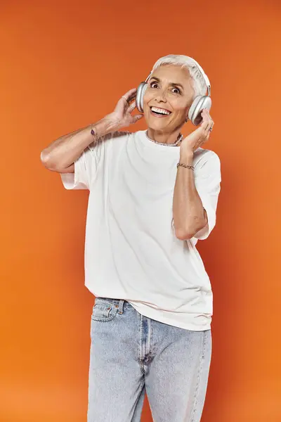 Mature woman revels in music, showcasing her unique style and joyful expression. — Stock Photo